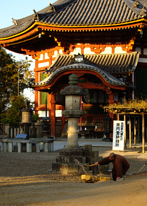 Sunrise at a temple in Nara, where a monk is throwing water around.